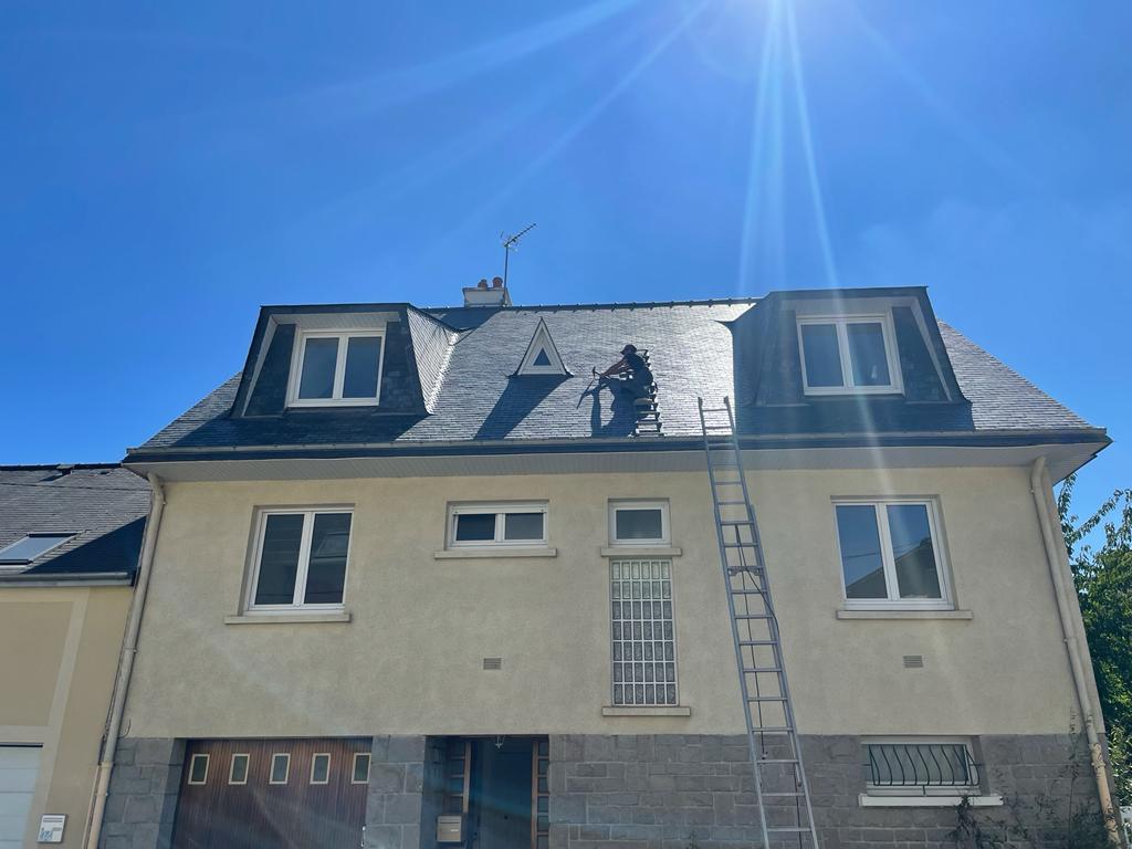 Travailleur sur le toit d'une maison sous le soleil.
