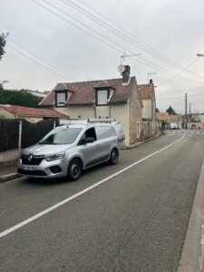 Fourgon gris stationné devant maison en France.
