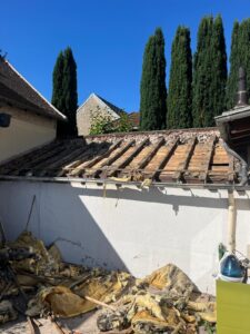 Toit de maison en réparation avec isolation endommagée.