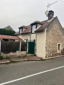 Maison ancienne avec toit en tuiles, rue tranquille.