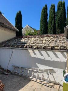 Échelle contre mur sous toit incliné.