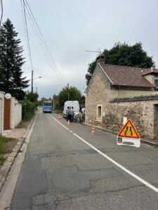 Rue fermée pour travaux avec panneau et camionnette.