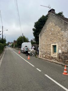 Rue avec camionnette et cônes de signalisation.