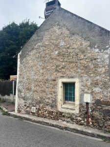 Vieille maison en pierre en bord de route.