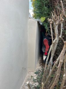 Travail de peinture en extérieur sur un mur.