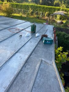 Travail de toiture en cours, outils et matériel visibles.