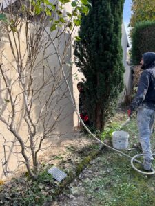 Travailleurs préparant un mur extérieur pour rénovation.