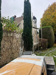 Travailleurs rénovant un toit avec échafaudages extérieurs.